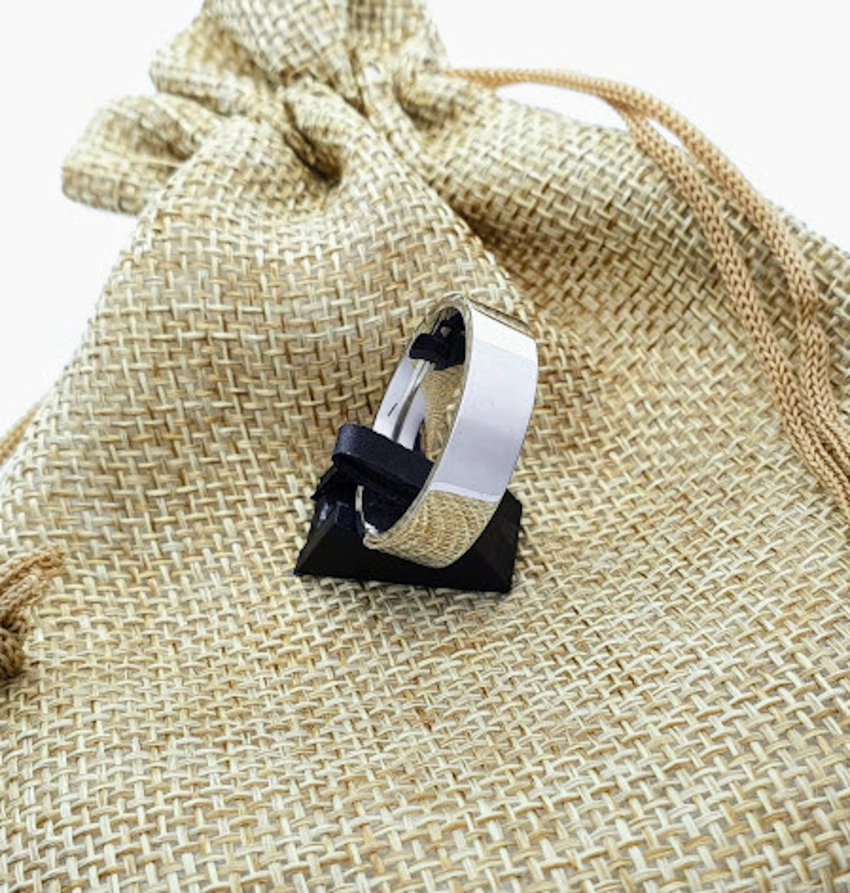 Anillo plano de acero inoxidable presentado con bolsa de tela.