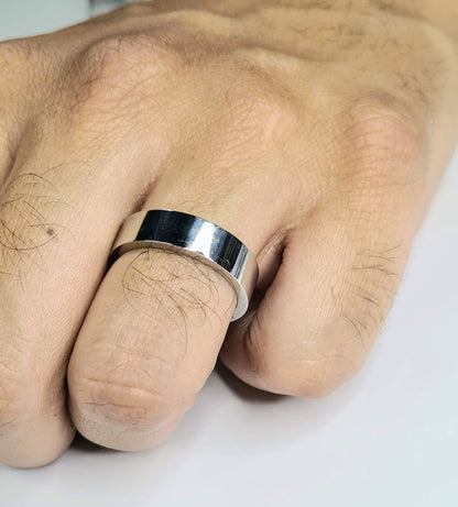 Primer plano de alianza plana plateada de 6 mm en mano masculina.