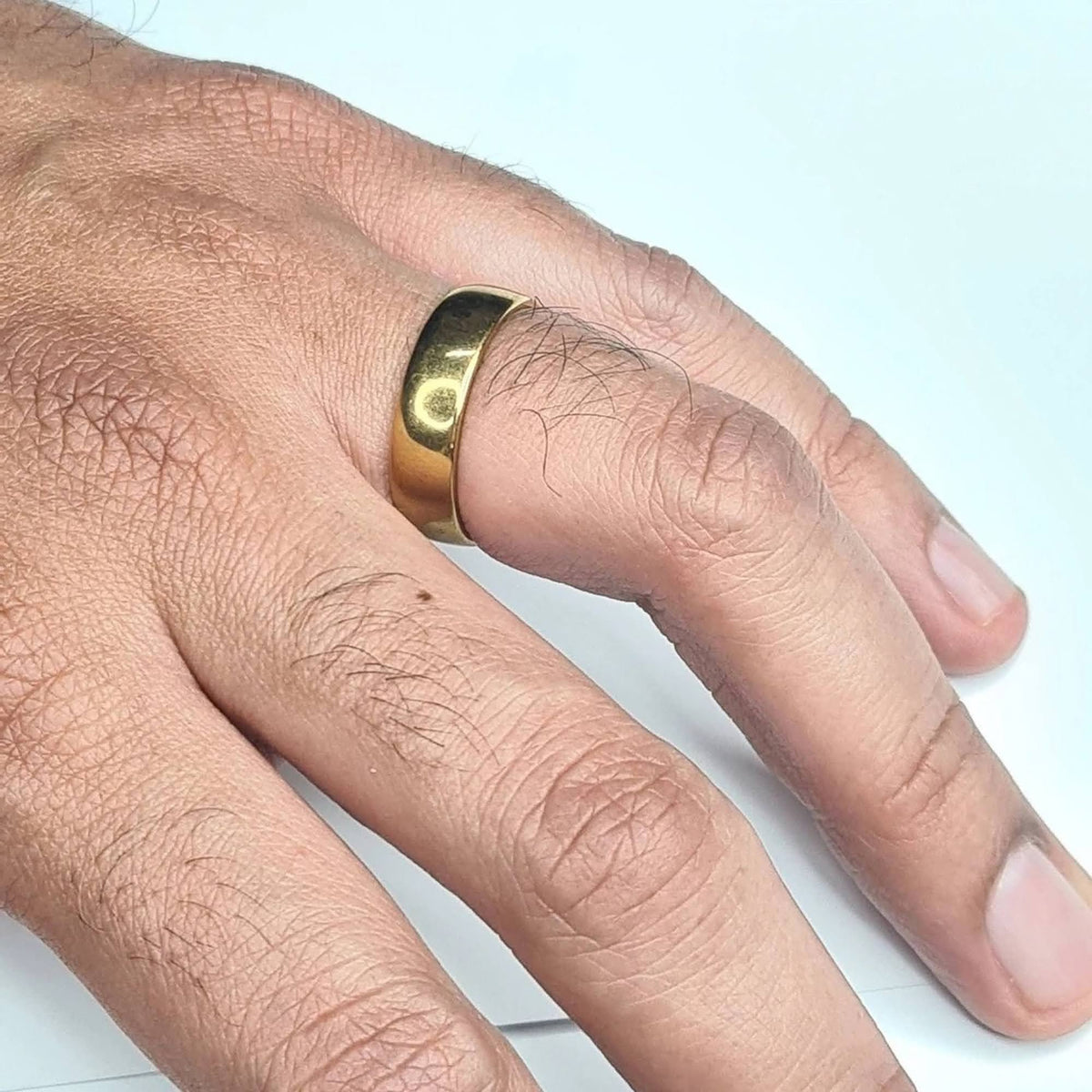 Alianza dorada media caña de 6 mm puesta en mano de hombre.