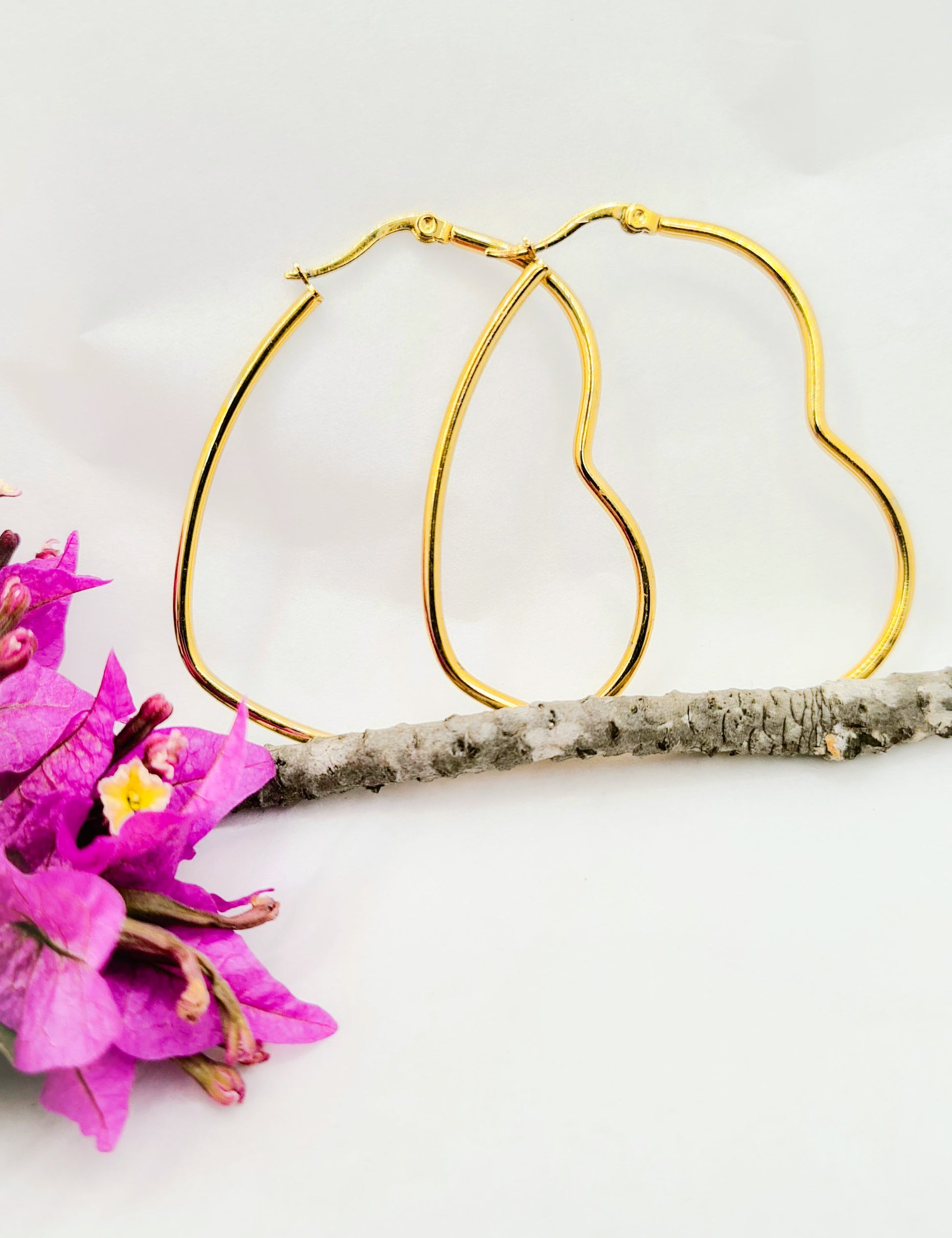 Aros forma de Corazón varias medidas en acero inoxidable dorado. Posa sobre fondo blanco.