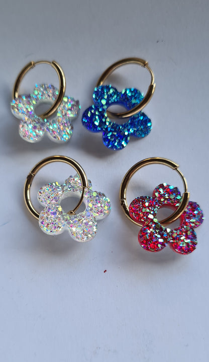 Aros acero inoxidable dorados con Flor de Acrílico Brillante para mujer. Fondo blanco.