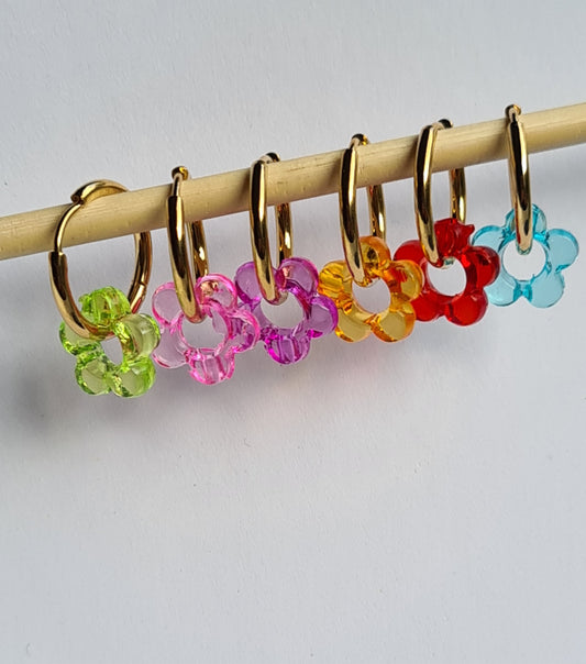 Aros acero inoxidable dorados con Flor de Acrílico para mujer. Fondo blanco.