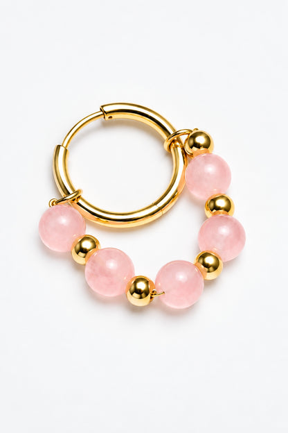 Aro de acero inoxidable dorado con cuentas de cuarzo rosa sobre fondo claro.