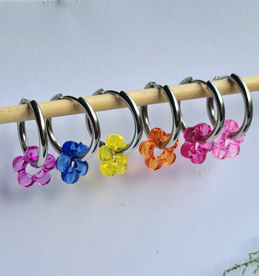 Aros acero inoxidable plateados con Flor de Acrílico para mujer. Fondo blanco.