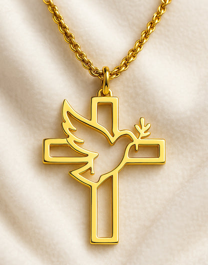 Colgante dorado con diseño de cruz calada y paloma con rama de olivo sobre fondo claro.