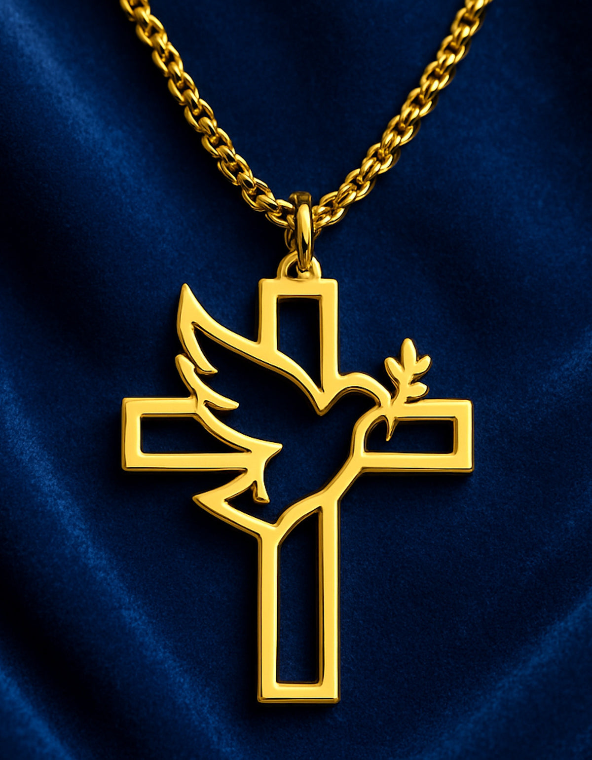Detalle del colgante dorado con cruz calada y paloma sobre fondo azul oscuro.