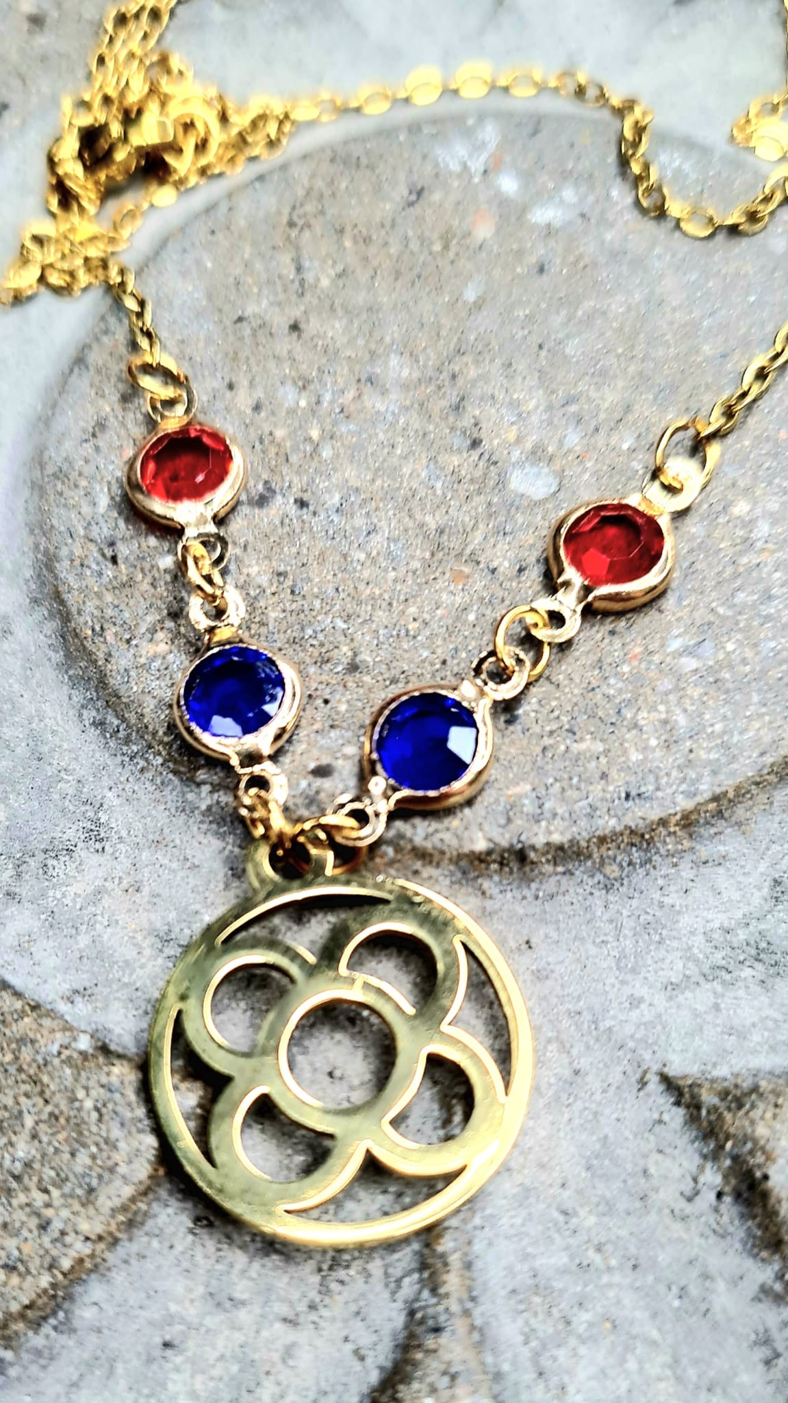 Colgante con la Flor de Barcelona redonda de acero inoxidable con cristal azul y rojo para mujer.