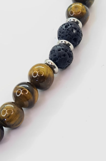 Collar de cuentas Ojo de Tigre, Lava volcánica y Discos de Acero. Posa sobre fondo blanco.