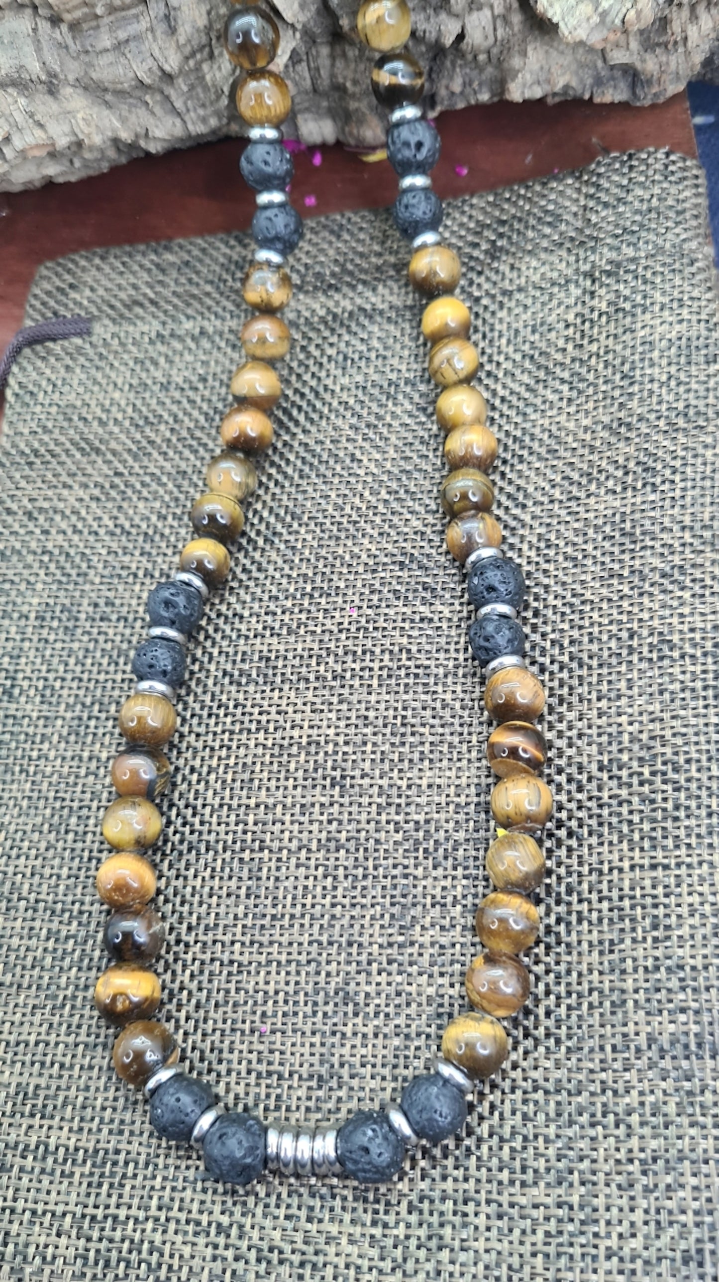 Collar de cuentas Ojo de Tigre, Lava volcánica y Discos de Acero. Posa sobre saquito.