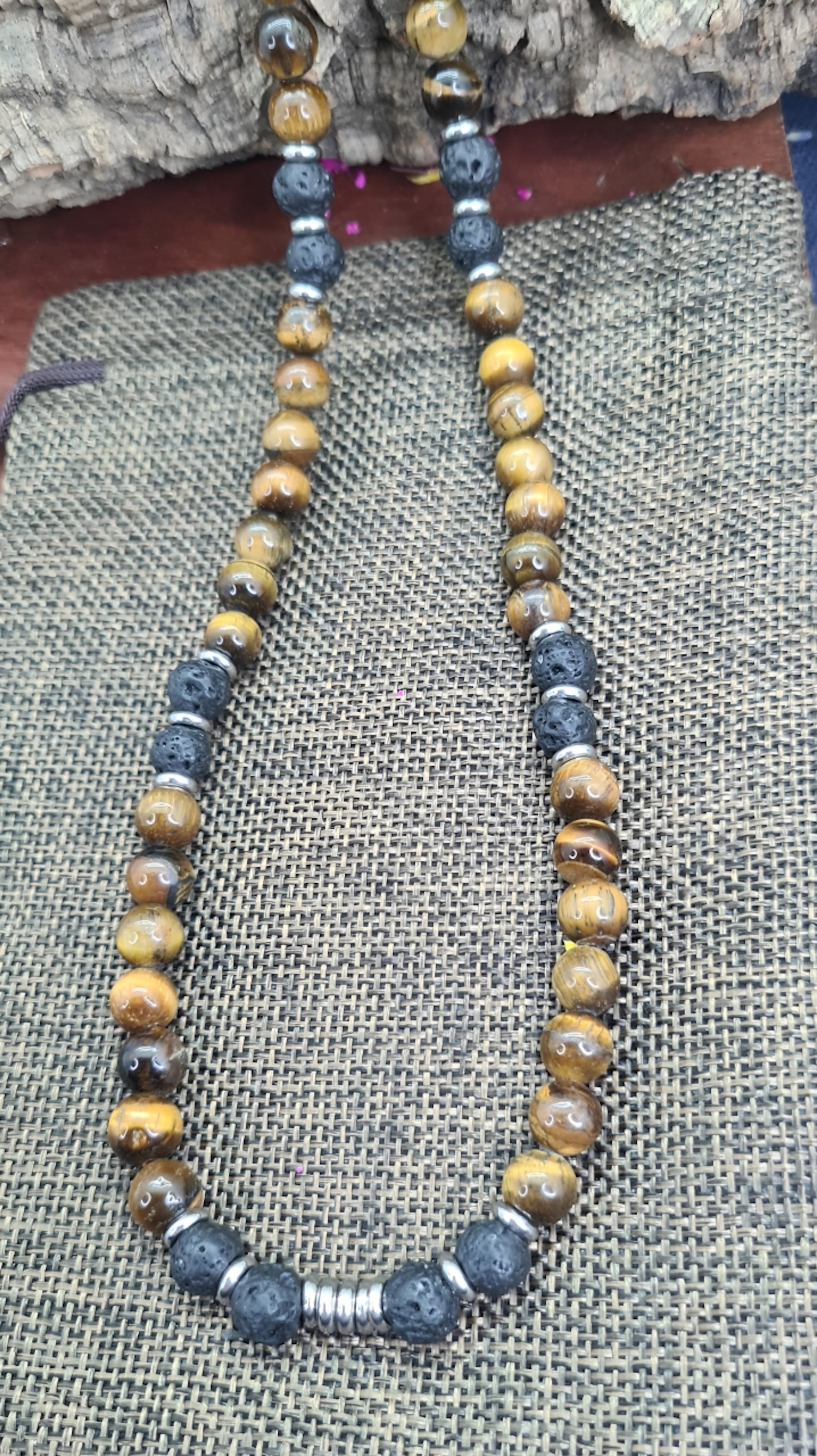 Collar de cuentas Ojo de Tigre, Lava volcánica y Discos de Acero. Posa sobre saquito.