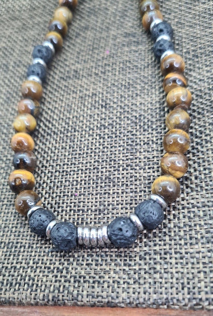 Collar de cuentas Ojo de Tigre, Lava volcánica y Discos de Acero. Posa sobre saquito.