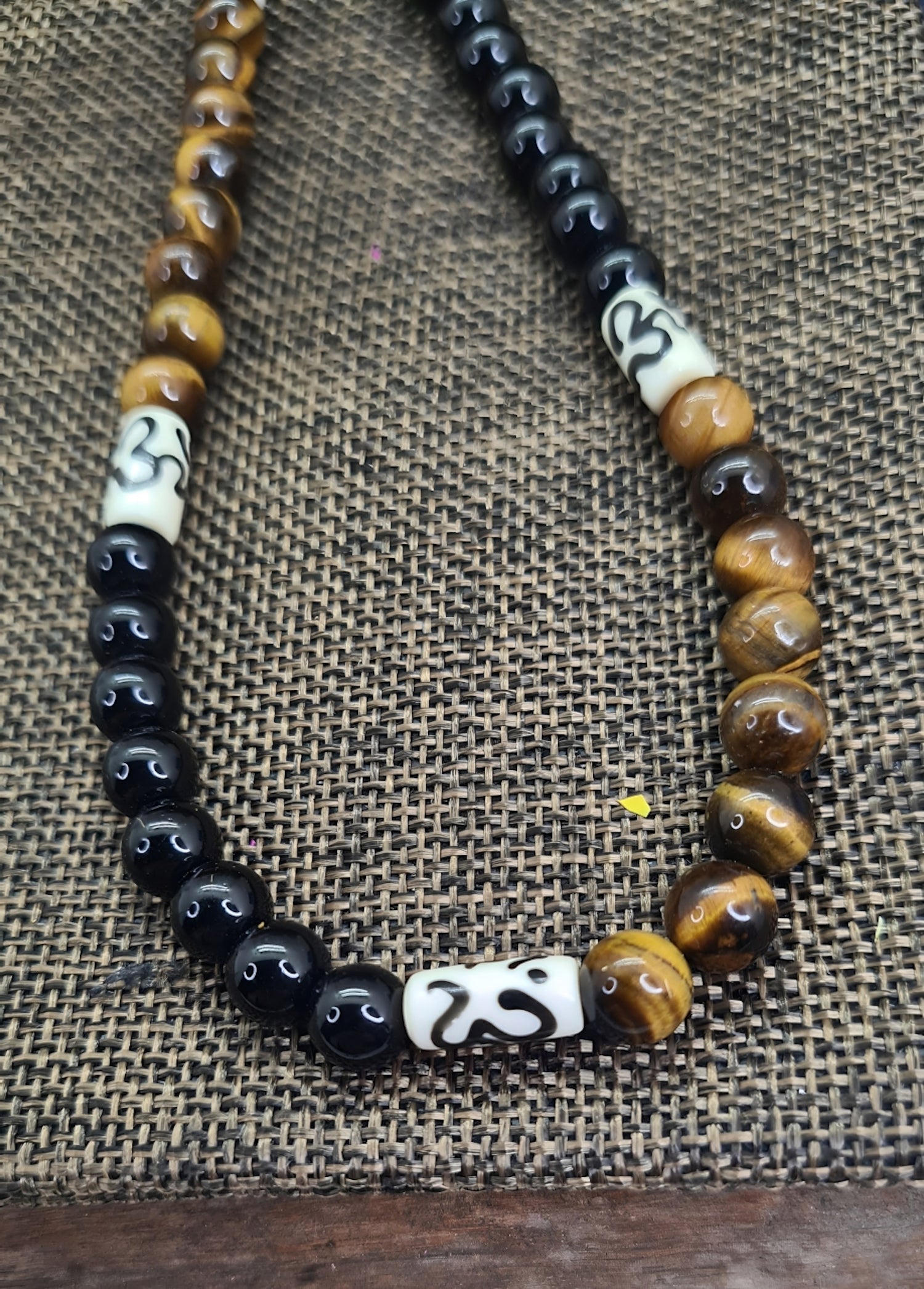 Collar para hombres con cuentas de Ojo de Tigre, Ónix y Hueso de Yak. Posa sobre saquito.