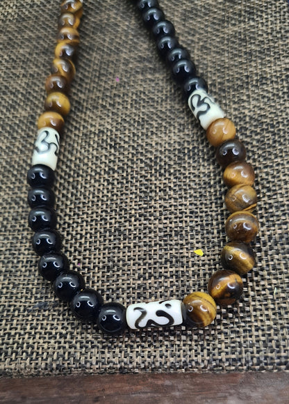 Collar para hombres con cuentas de Ojo de Tigre, Ónix y Hueso de Yak. Posa sobre saquito.