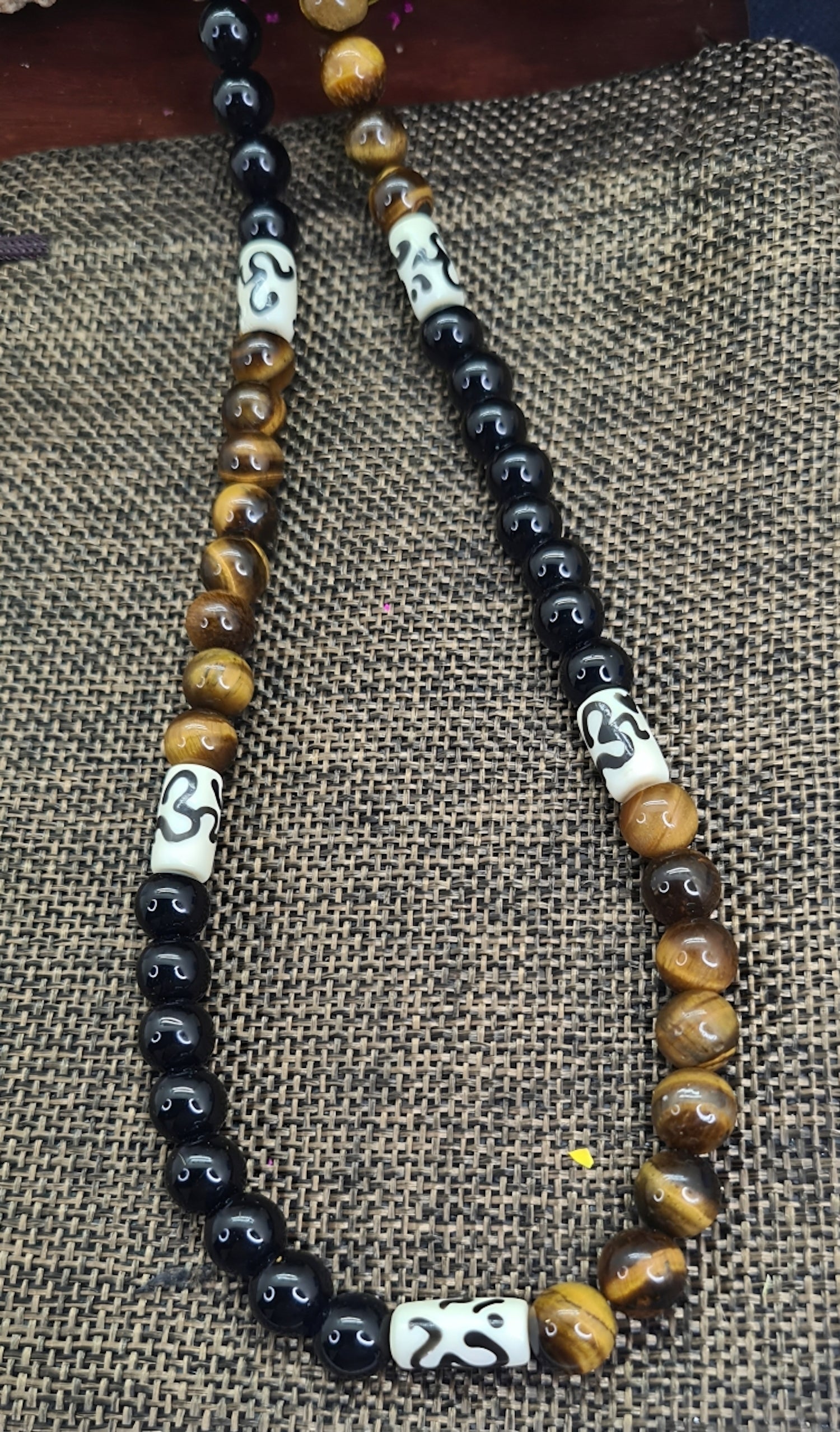Collar para hombres con cuentas de Ojo de Tigre, Ónix y Hueso de Yak. Posa sobre saquito.