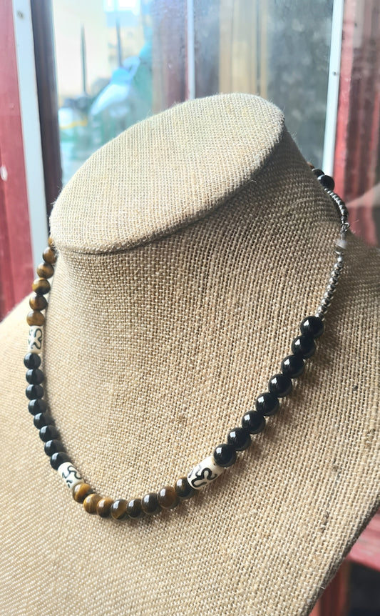 Collar para hombres con cuentas de Ojo de Tigre, Ónix y Hueso de Yak. Posa sobre cuello.