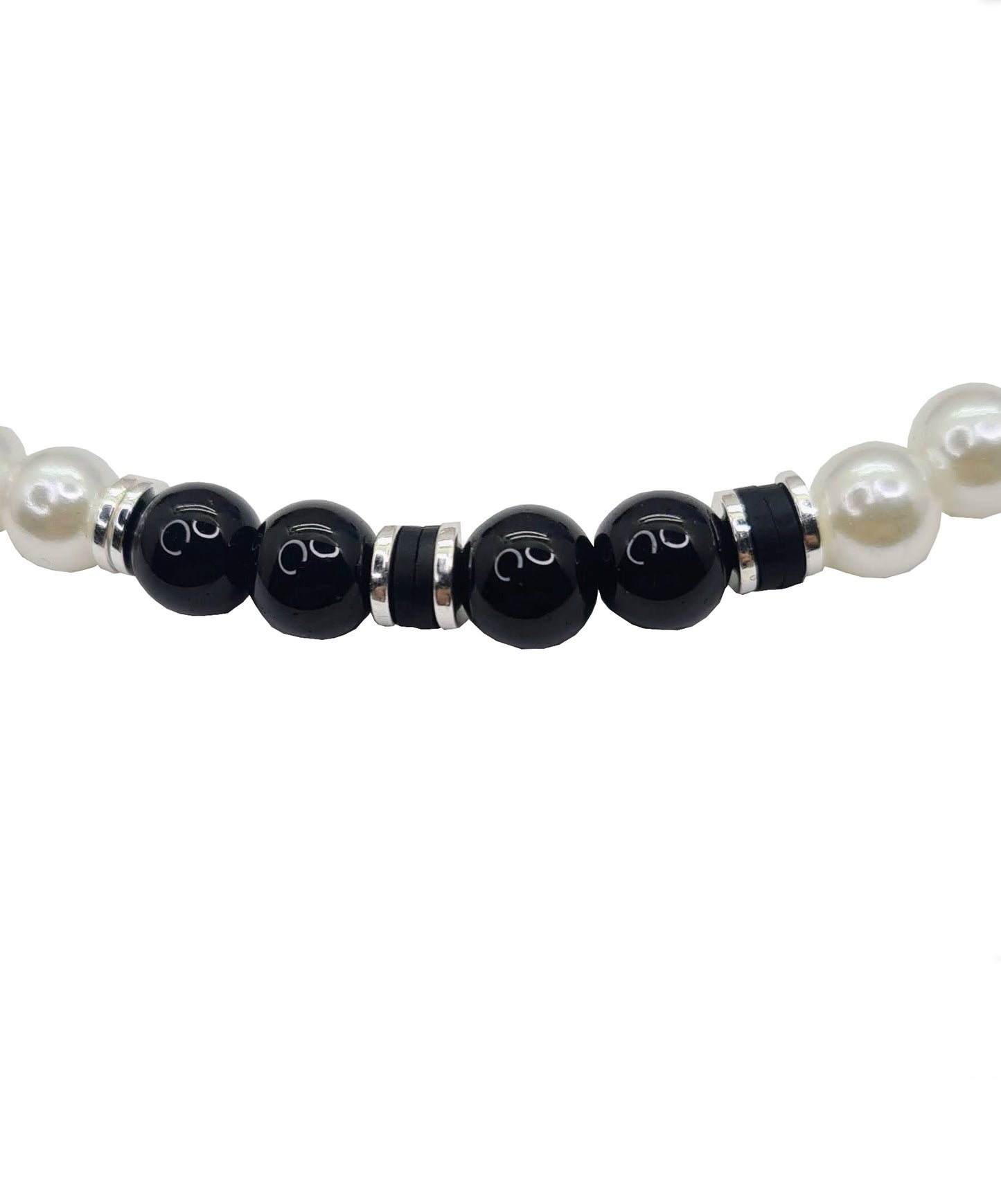Collar unisex cuentas de Perlas, Discos de Arcilla y Acero, y Ónix. Posa sobre fondo blanco.