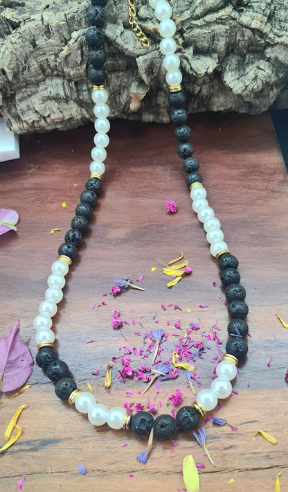Collar unisex cuentas de Perlas, acero y Lava volcánica negra. Posa sobre madera.