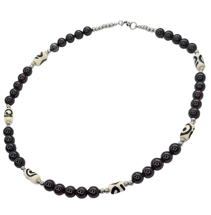 Collar para Hombre con cuentas de Granate y Hueso de Yak. Posa sobre fondo blanco.