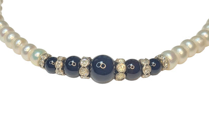 Collar de perlas con centro de cuentas negras de ónix y separadores brillantes.