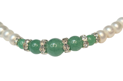 Collar de perlas con centro de jade verde y separadores brillantes.