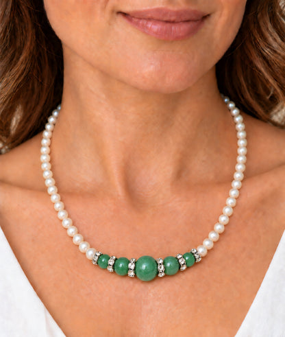 Mujer llevando collar de perlas con composición central de jade verde.