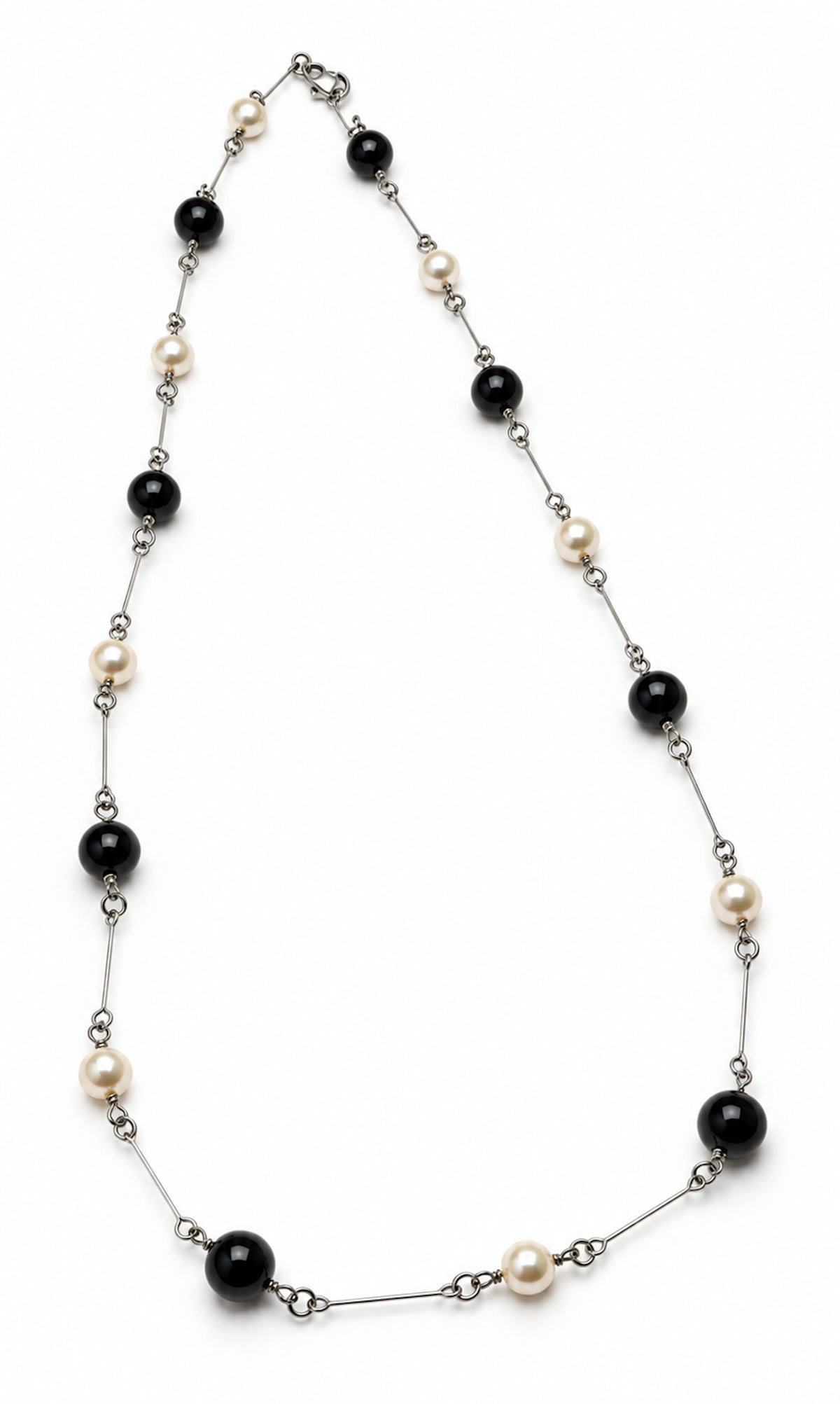 Collar largo de ónix negro y perlas unido con elementos metálicos.