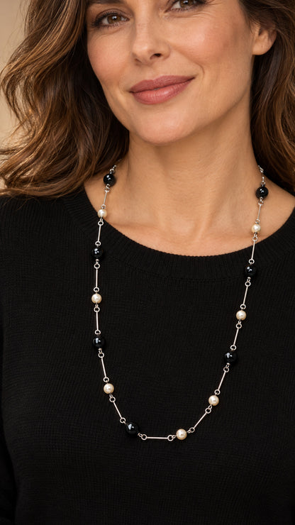 Mujer con collar largo de ónix negro y perlas.