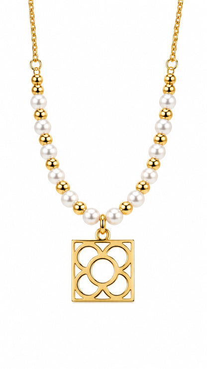Collar Flor de Barcelona dorado con perlas blancas sobre fondo blanco.
