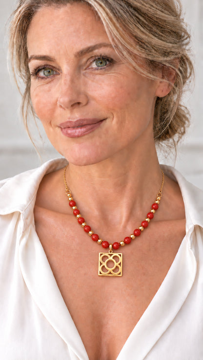 Collar Flor de Barcelona con coral manzana llevado por una mujer con camisa blanca.