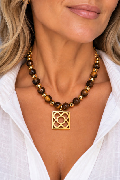 Collar Flor de Barcelona con ojo de tigre llevado por una mujer con camisa blanca.