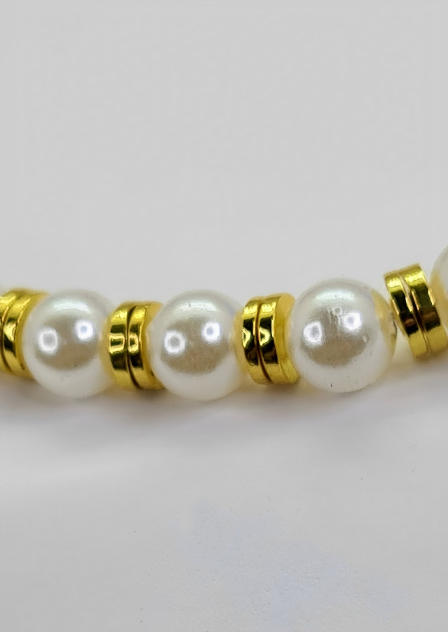 Collar Unisex Perlas y Discos Acero Dorados. Posa sobre fondo blanco.
