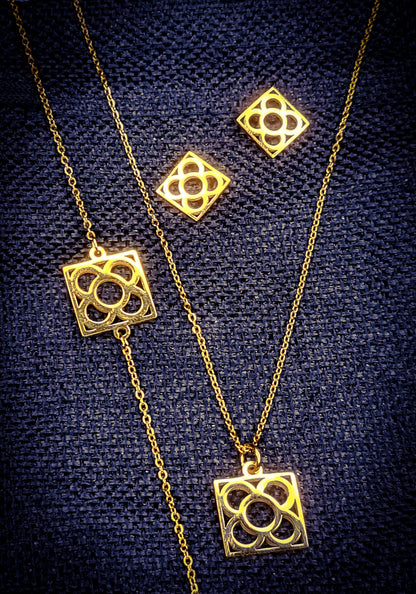 Conjunto Flor de Barcelona Acero Inoxidable dorado para mujer. Posa sobre saquito de arpillera.