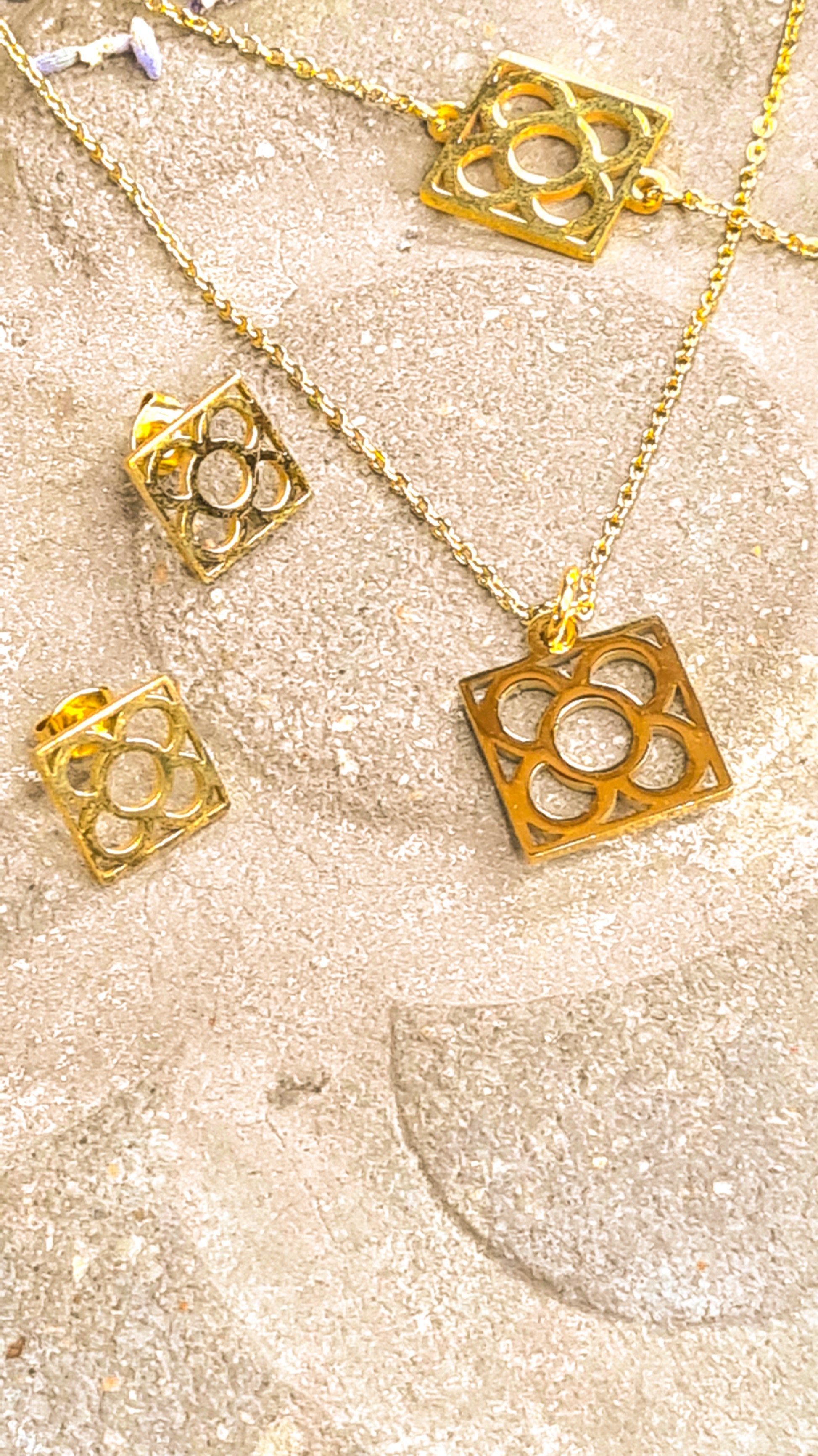 Conjunto Flor de Barcelona Acero Inoxidable dorado para mujer. Posa sobre baldosa.