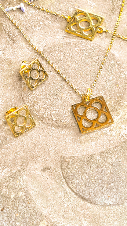 Conjunto Flor de Barcelona Acero Inoxidable dorado para mujer. Posa sobre baldosa.
