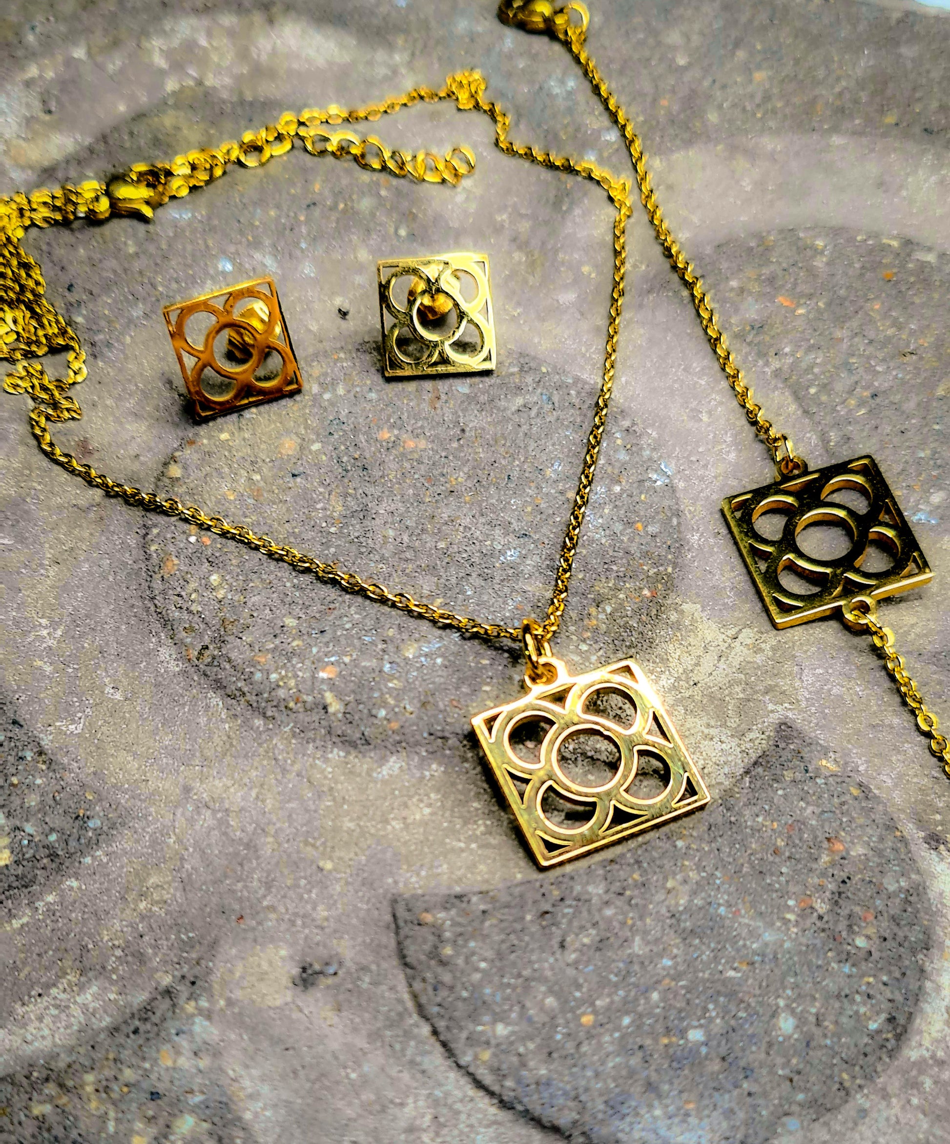 Conjunto Flor de Barcelona Acero Inoxidable dorado para mujer. Posa sobre baldosa.
