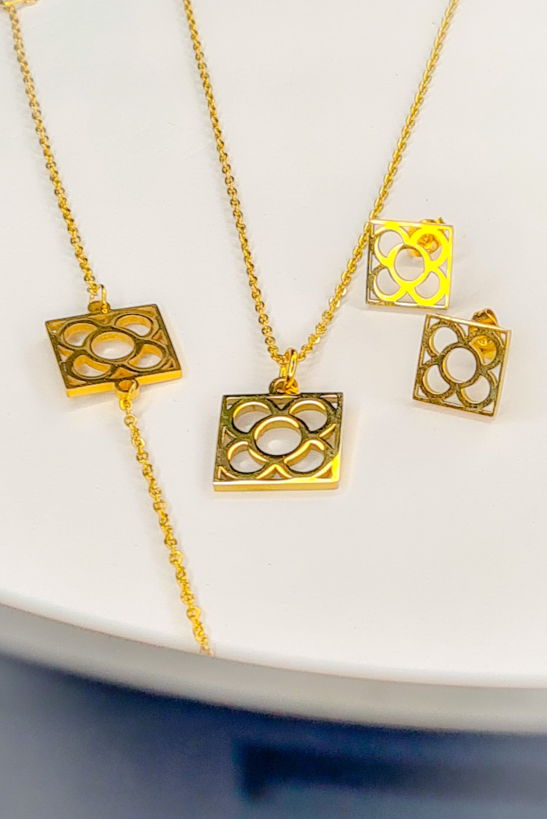 Conjunto Flor de Barcelona Acero Inoxidable dorado para mujer. Posa sobre fondo blanco.