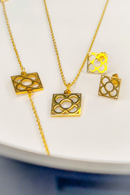 Conjunto Flor de Barcelona Acero Inoxidable dorado para mujer. Posa sobre fondo blanco.