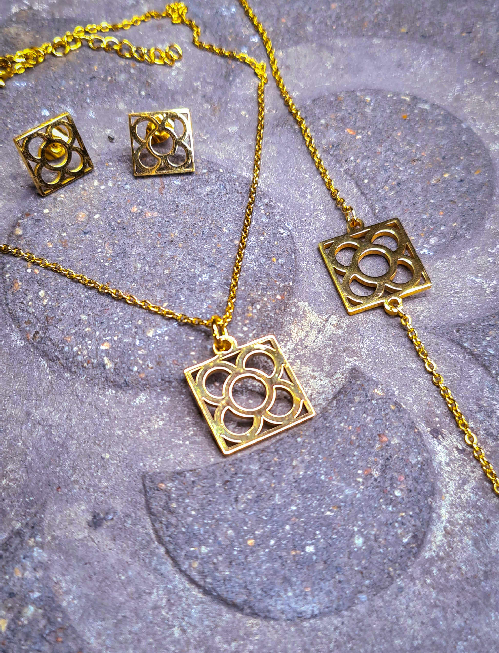Conjunto Flor de Barcelona Acero Inoxidable dorado para mujer. Posa sobre baldosa.