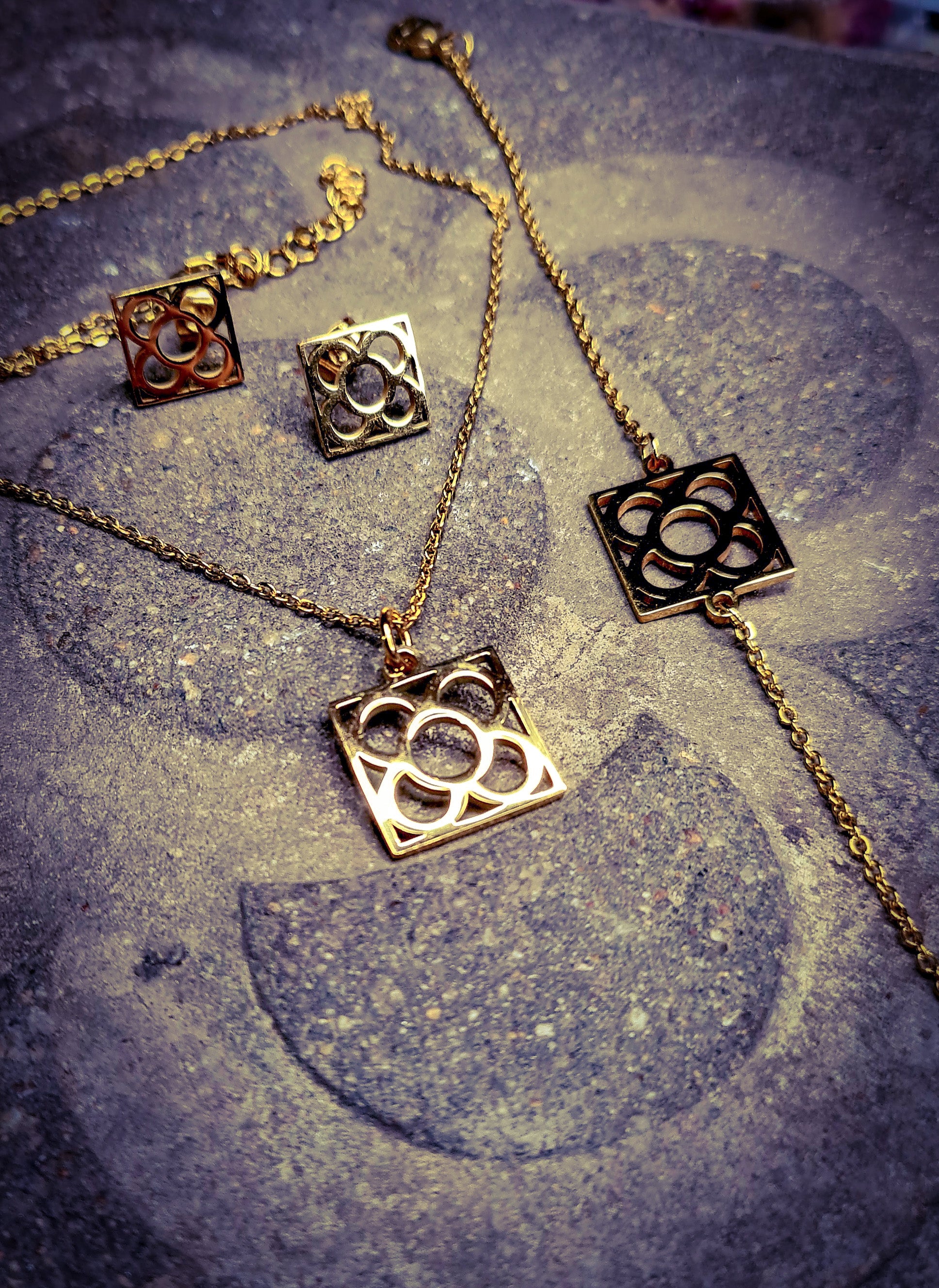 Conjunto Flor de Barcelona Acero Inoxidable dorado para mujer. Posa sobre baldosa.