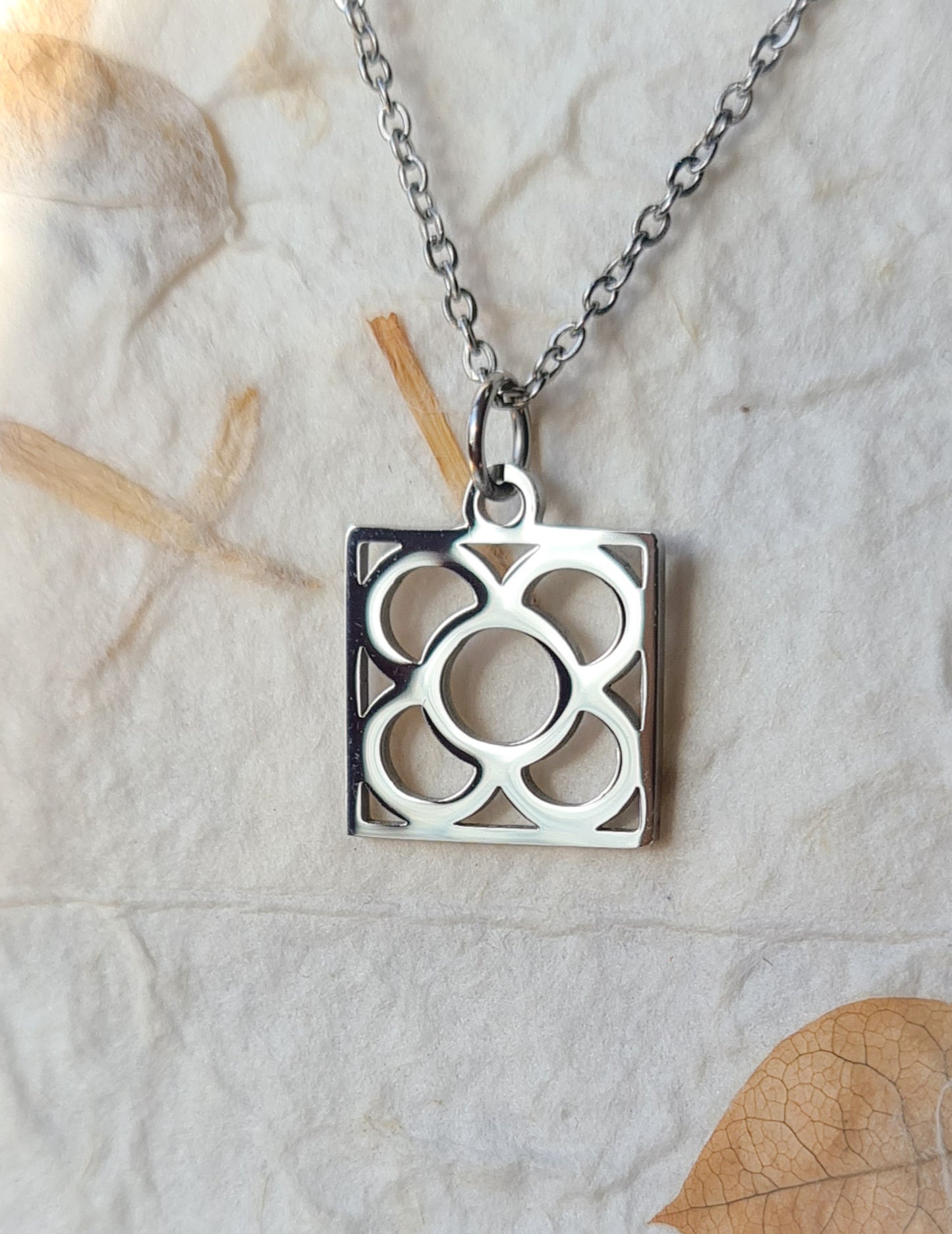 Conjunto Flor de Barcelona Acero Inoxidable para mujer. Posa sobre bolsa de papel.