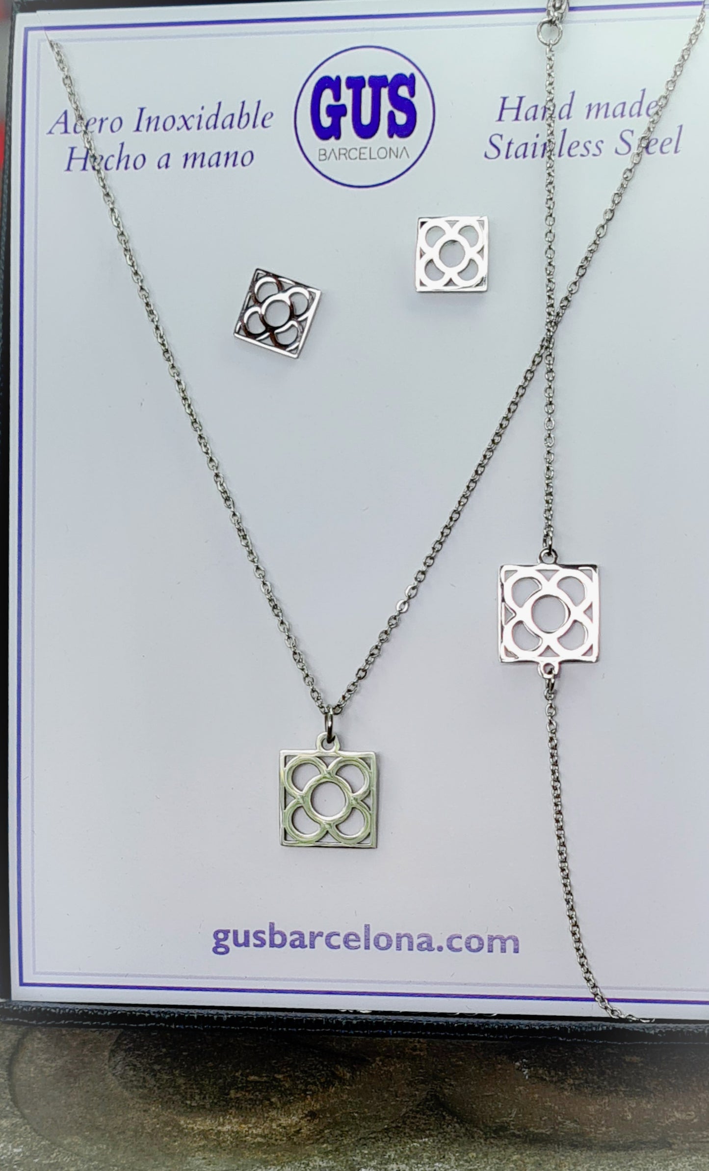 Conjunto Flor de Barcelona Acero Inoxidable para mujer. Posa sobre cartón blanco.