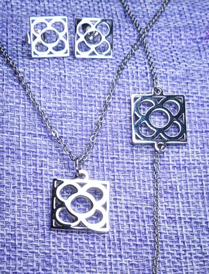 Conjunto Flor de Barcelona Acero Inoxidable para mujer. Posa sobre saquito de arpillera.