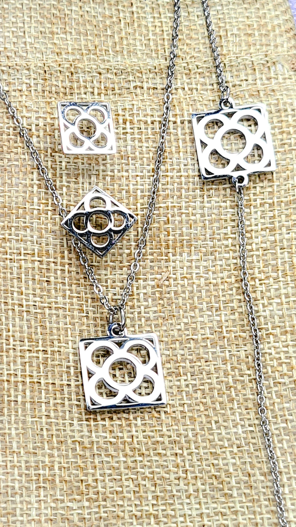 Conjunto Flor de Barcelona Acero Inoxidable para mujer. Posa sobre saquito de arpillera.