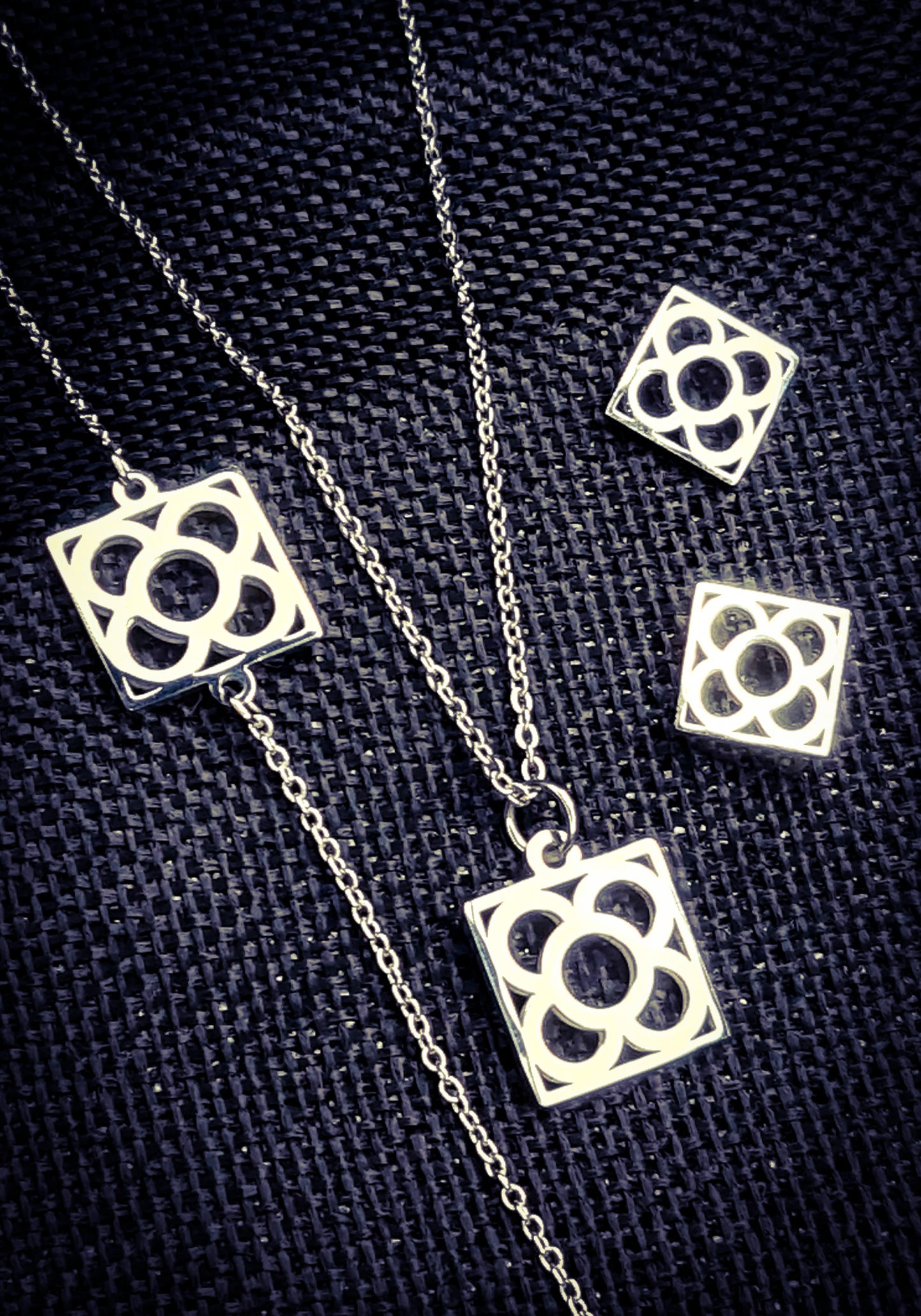 Conjunto Flor de Barcelona Acero Inoxidable para mujer. Posa sobre saquito de arpillera.