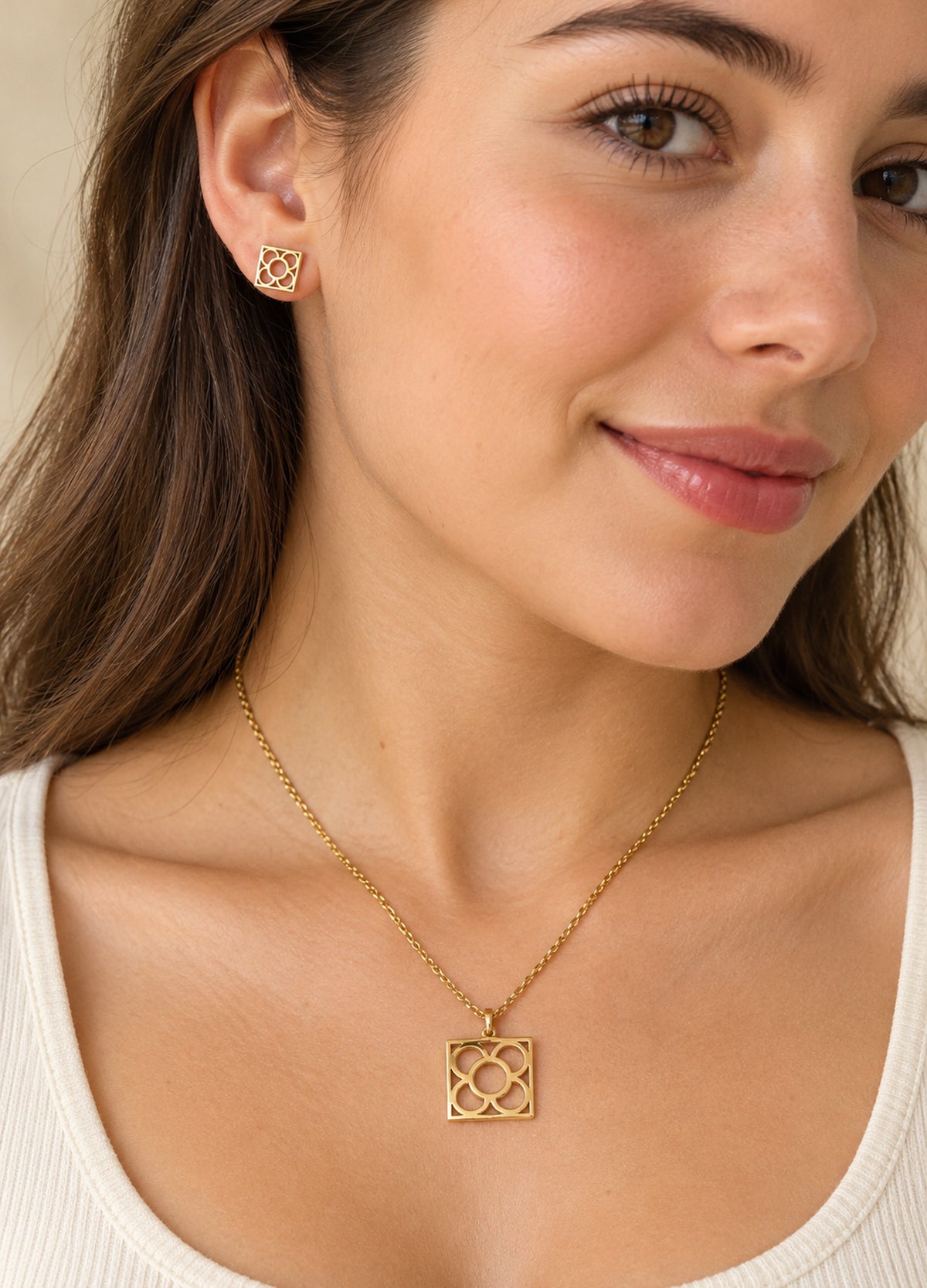 Modelo llevando colgante y pendientes dorados Flor de Barcelona.