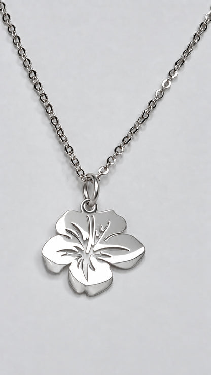 Colgante floral pequeño de acero inoxidable en acabado plateado con cadena.