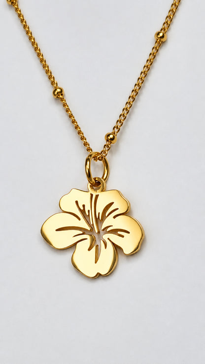 Colgante floral pequeño de acero inoxidable en acabado dorado con cadena.