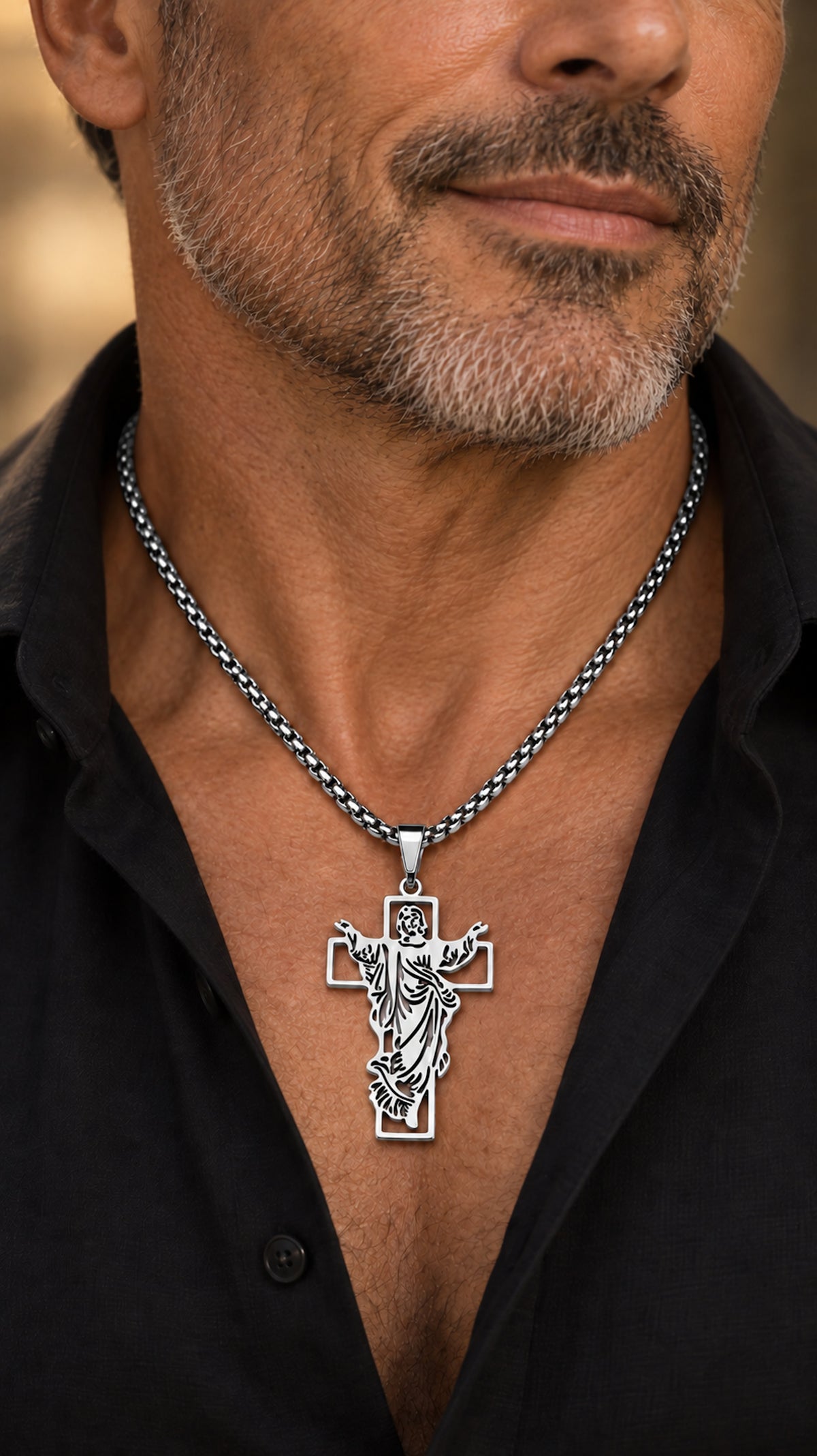 Cruz con Jesús plateada de acero inoxidable con cadena de 60 cm llevada por un hombre.
