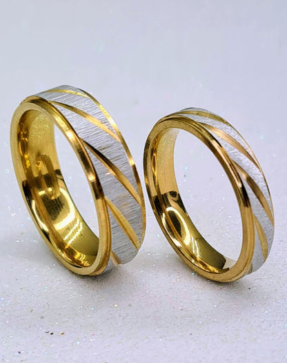 Set de dos alianzas bicolor de acero inoxidable de 4 y 6 mm con detalles diagonales dorados.