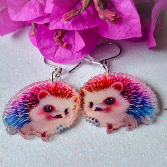 Pendientes Erizo para mujer en Acero y Acrílico. Posa sobre fondo blanco y flores.